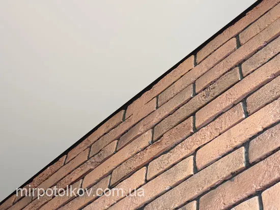 цегла на стіні та тіньова натяжна стеля